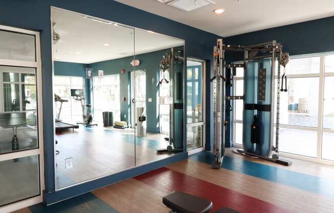 a fitness room with mirrors and exercise equipment