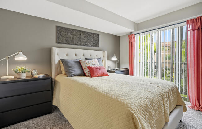 A bedroom with a large bed and a black dresser.