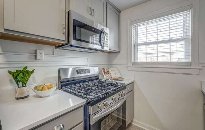 A kitchen with a stove top oven and a microwave above it.