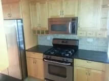 a kitchen with a stove and a microwave and a refrigerator at Bryant II