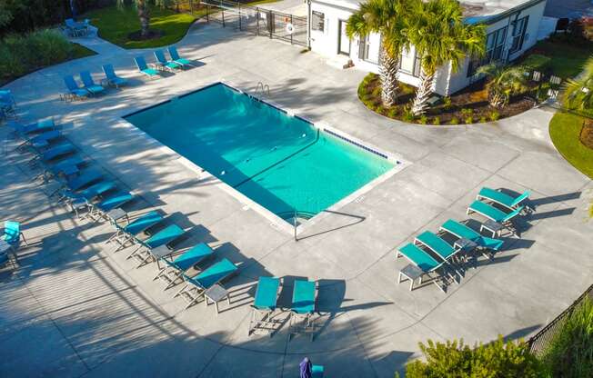 a swimming pool with chairs and chairs around it