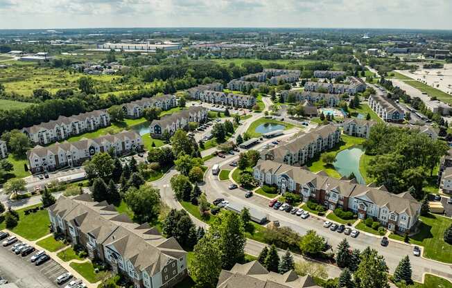A bird's eye view of a residential area with houses, roads, and a swimming pool
