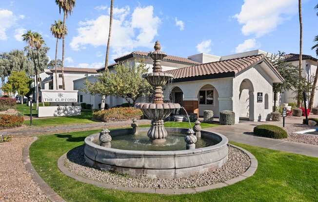 A fountain in front of a building with a sign that says "The Clifford".