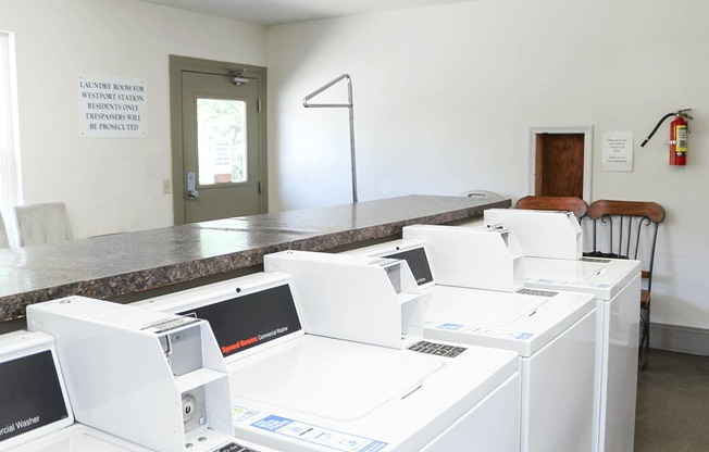 A laundromat with washing machines and a sign that says