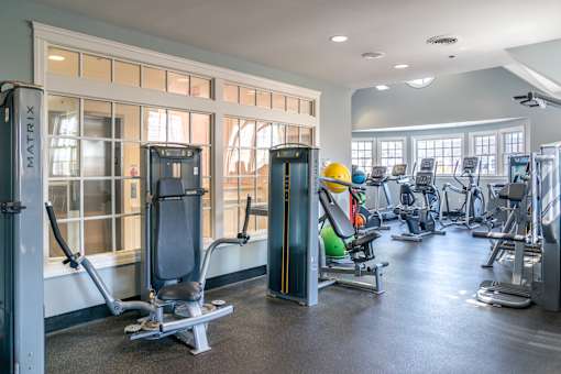 A gym with a variety of equipment including a weight machine and a rowing machine.