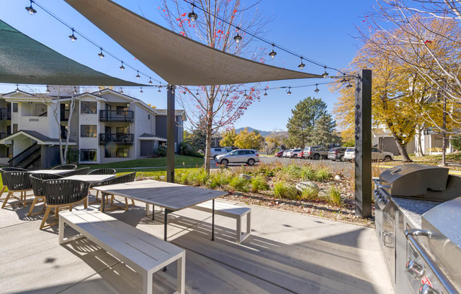 a patio with tables and chairs and a grill