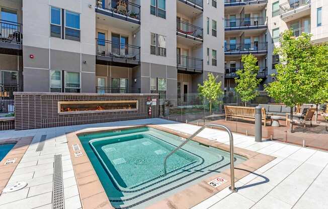 A small pool in a courtyard surrounded by buildings.