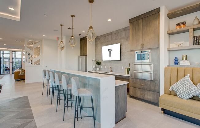 a large kitchen with a bar and chairs in front of it