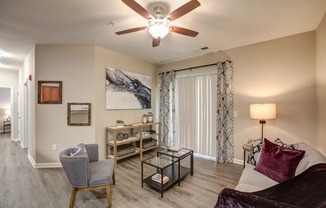 a living room with a ceiling fan and a sliding glass door