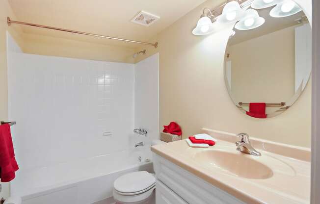 A white bathroom with a toilet, sink, and mirror.
