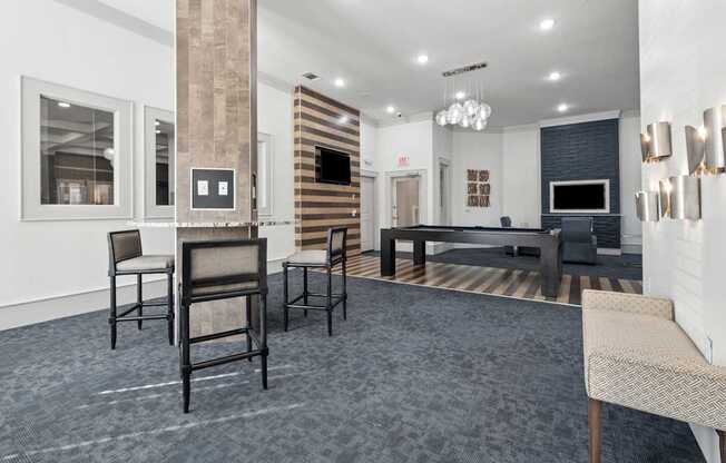 A living room with a grey carpet and a black couch.