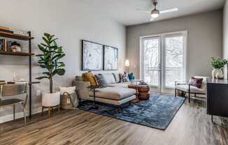 A living room with a couch, chairs, and a ceiling fan.