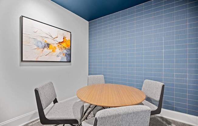A modern dining room with a round table and grey chairs.