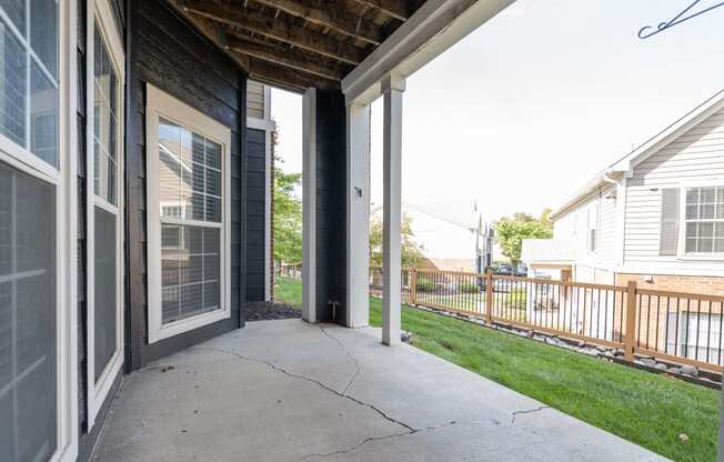 the front porch of a home with a concrete sidewalk and a wooden roof