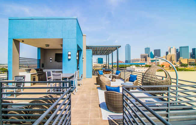 a rooftop patio with tables and chairs and a view of the city at South Side Flats, Dallas, 75215