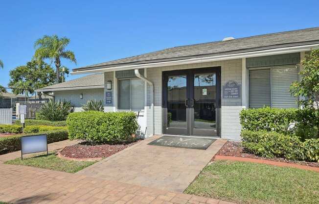 A building with a grey roof and a sign on the front door.
