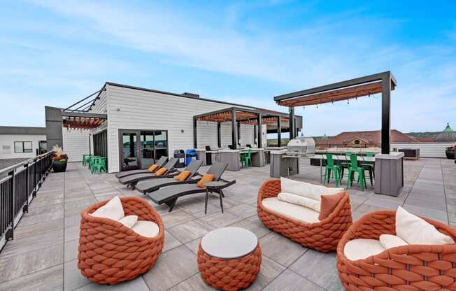 a rooftop patio with chairs and tables and a building in the background