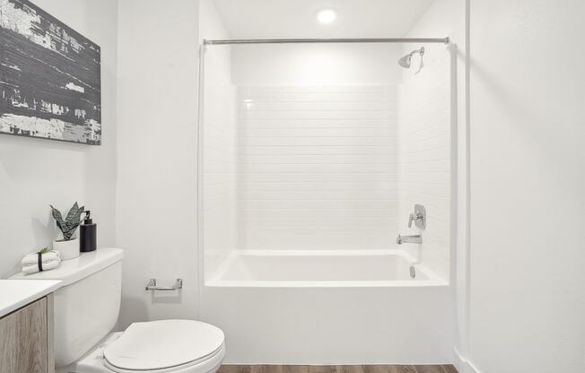 a white bathroom with a shower and a toilet