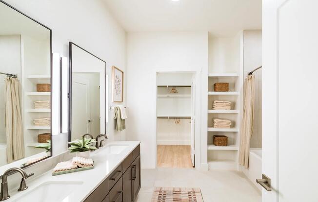 Spacious primary baths at Modera Trailhead feature dual vanities, open shelving, and seamless access to oversized closets.