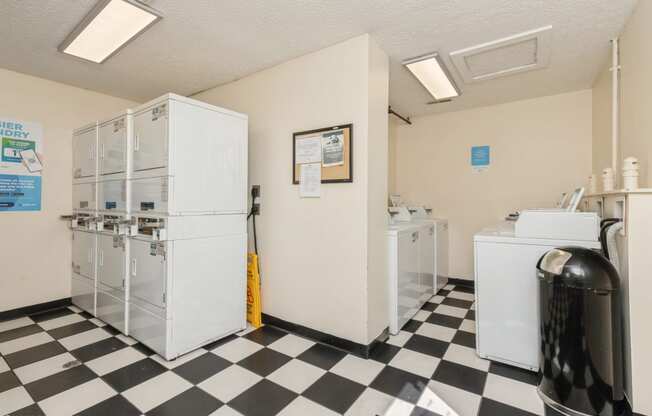 a laundry room with two refrigerators and a checkered floor