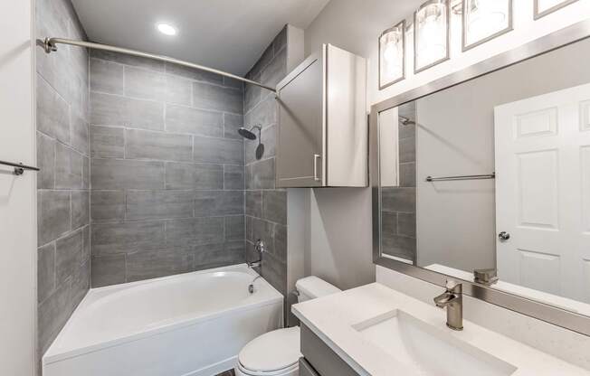 A bathroom with a white tub, sink, and toilet.