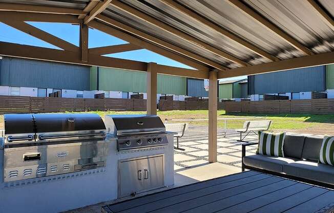 a patio with a grill and a table with chairs at Ivy Plains at Brooks Apartments, San Antonio