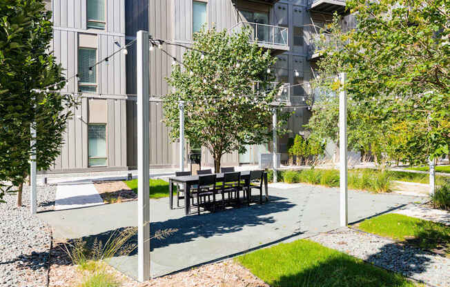 A modern building with a tree and bench in front.