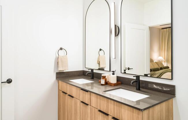 This refined primary bath finish option at Modera Nations in Nashville features sleek double vanities, modern fixtures, and a clean, timeless design.