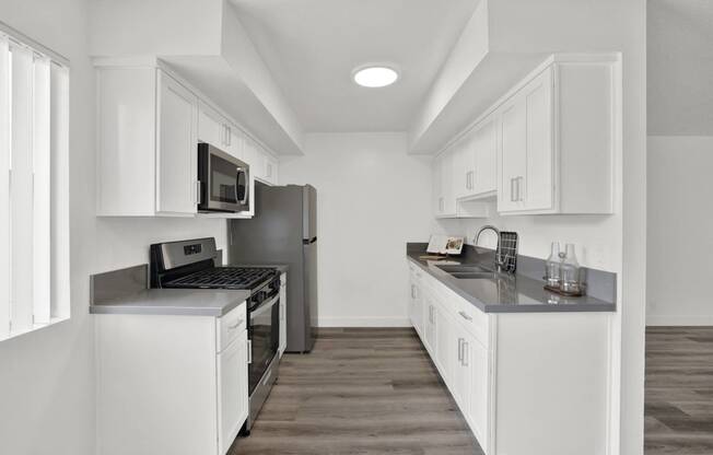 a kitchen with white cabinets and stainless steel appliances