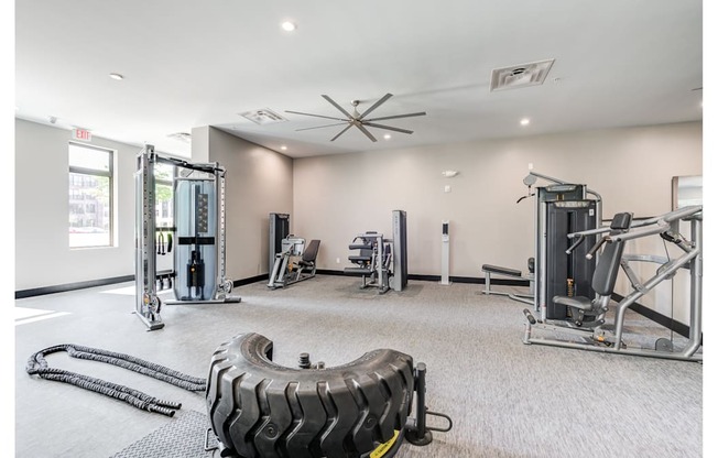 A gym with a variety of equipment including a tire flipping machine.