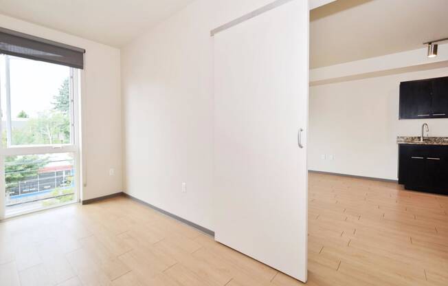 a bedroom with a sliding door that leads to a kitchen