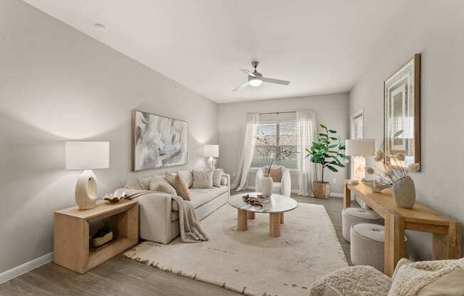 A living room with a white sofa, a wooden coffee table, and a large painting on the wall.