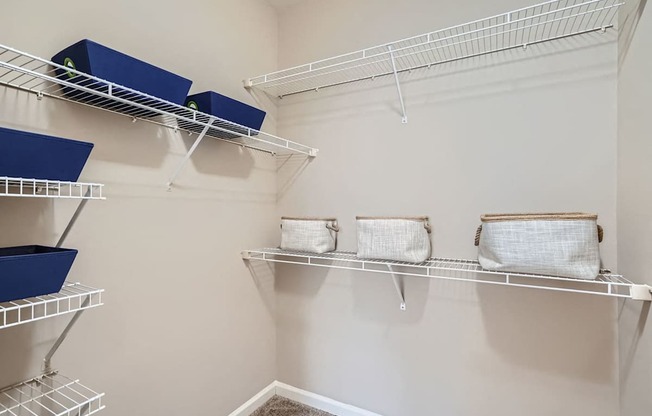 A white shelving unit with blue and white bins and bags.