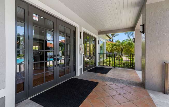 A glass door with a black mat in front of it.