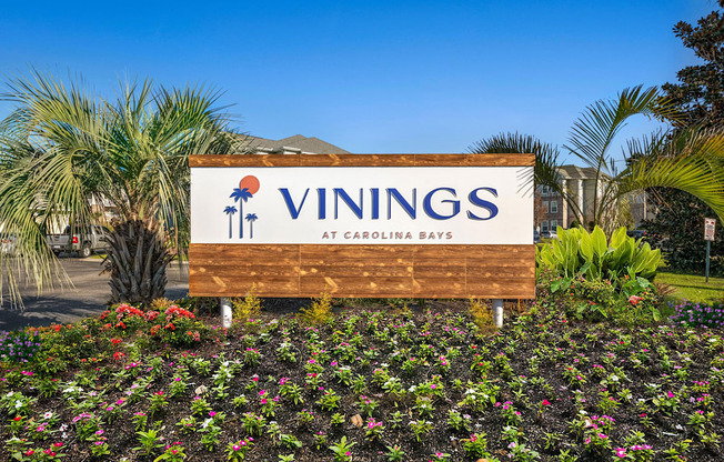 a sign for the vinings at carolina blvd in front of plants