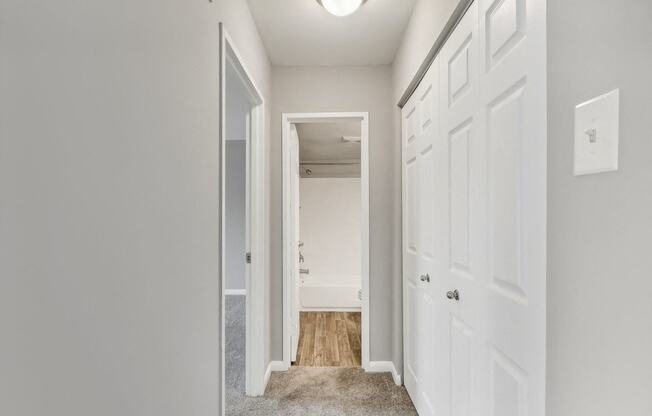 a bedroom with white doors and a hallway with a door to a closet
