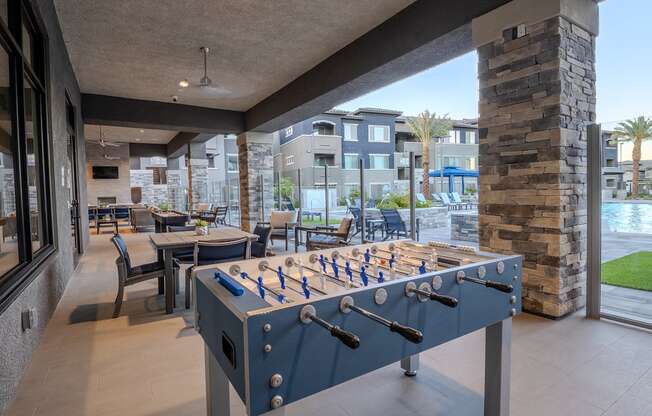 A foosball table on a large patio overlooking the pool.