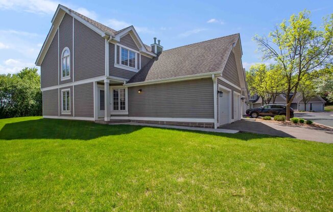 a gray house with a yard in front of it