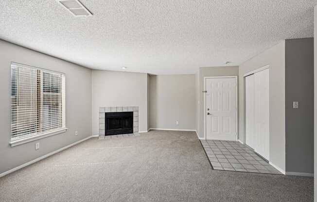 an empty living room with a fireplace and a white door