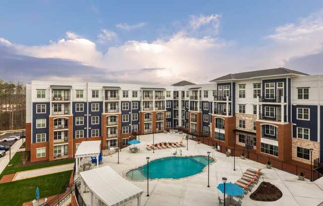 an aerial view of an apartment building with a swimming pool at The Bella at Westchester, Midlothian, VA