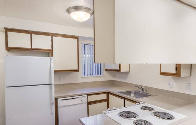 an empty kitchen with a stove and a refrigerator