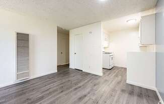 A room with a white fridge and a white cabinet.