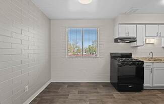 A kitchen with a black stove and white cabinets.