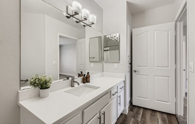 a bathroom with white cabinets and a white door