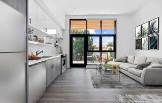 White living room with a kitchen and a balcony at Edendale Crossing, CA 90026