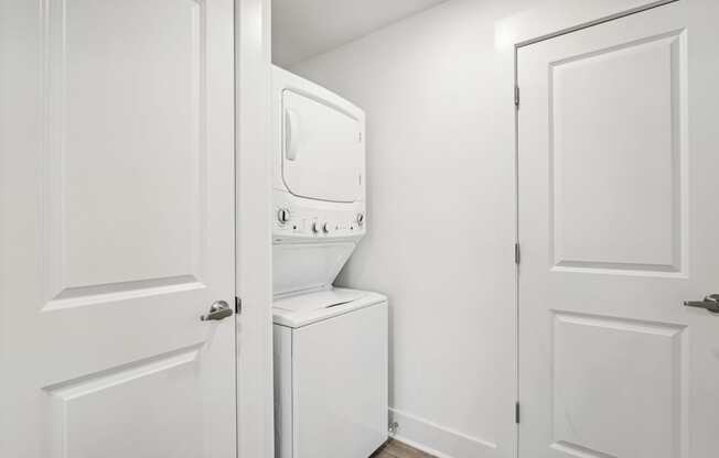 A white door is open to a small bathroom with a toilet and sink.