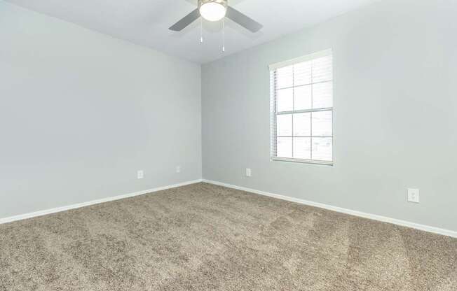 A room with a ceiling fan and a window.