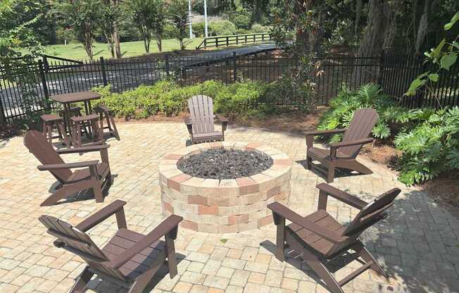 A fire pit surrounded by chairs in a backyard.