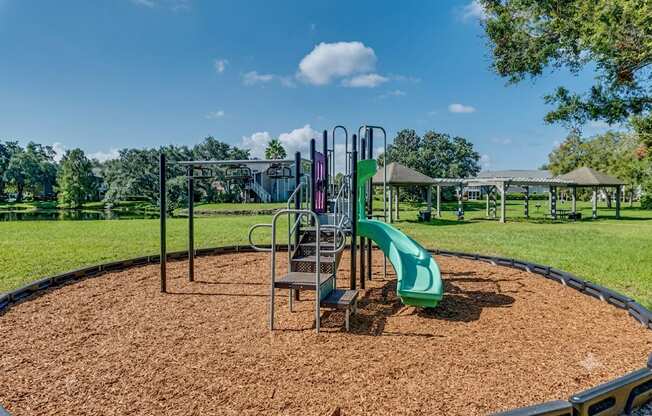 A playground with a green slide and a metal structure.