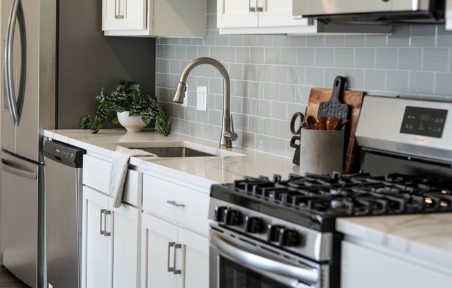 a kitchen with white cabinets and stainless steel appliances